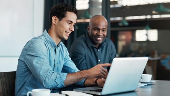 Couple of people discussing in front of laptop.