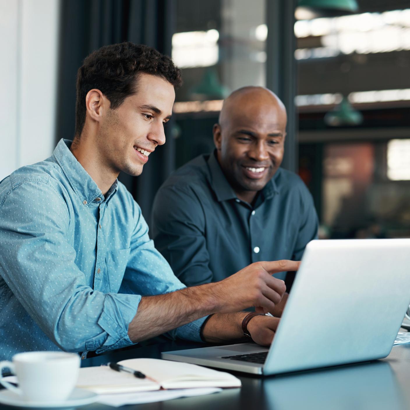 Teamwork, diversity and sales manager planning branding ideas with a creative designer on a laptop in an office. Logo, collaboration and businessman talking to an employee about a development project.