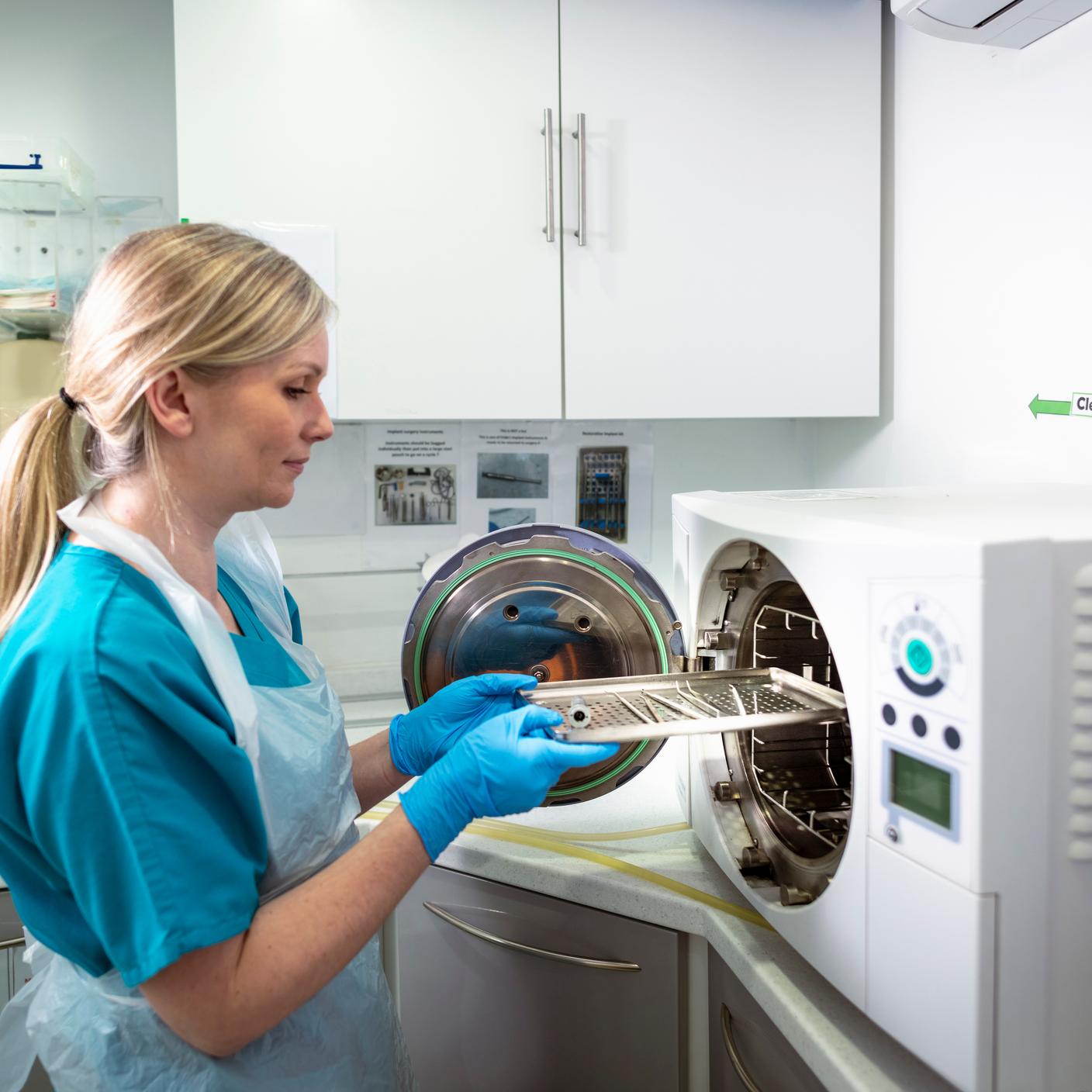 Equipe médica esterilizando dispositivos médicos em uma máquina de esterilização