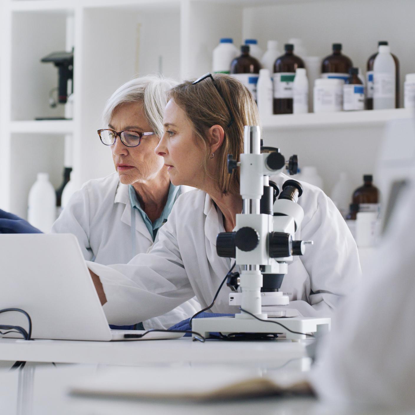 Science, medicine and research, women in laboratory with laptop and equipment.