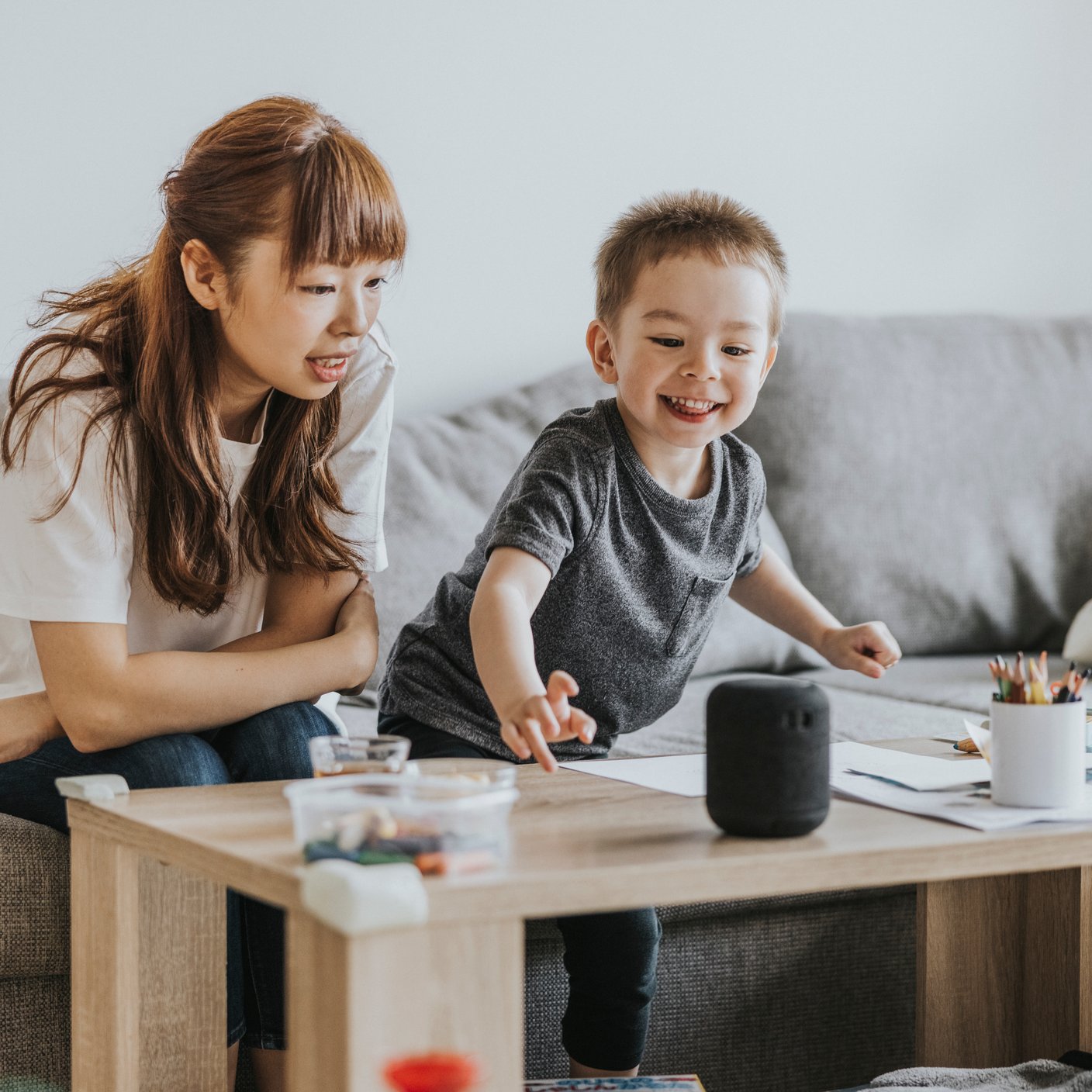 Mother and son at home, communicating with smart speaker.