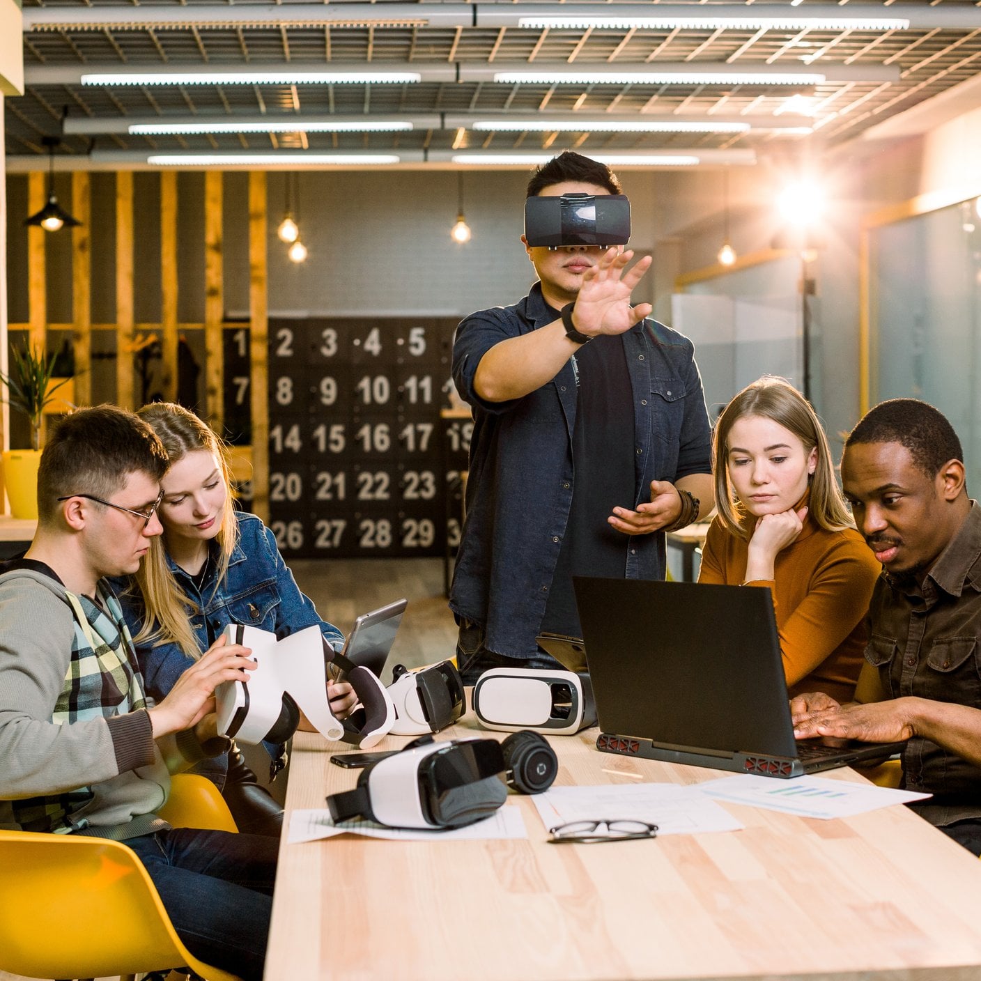 Teamwork trying virtual reality glasses for work in creative office.
