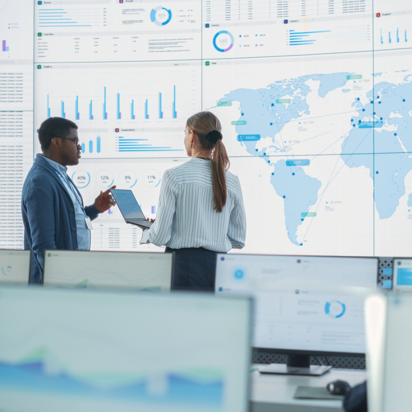 Employees discussing data analytics in front of big screen
