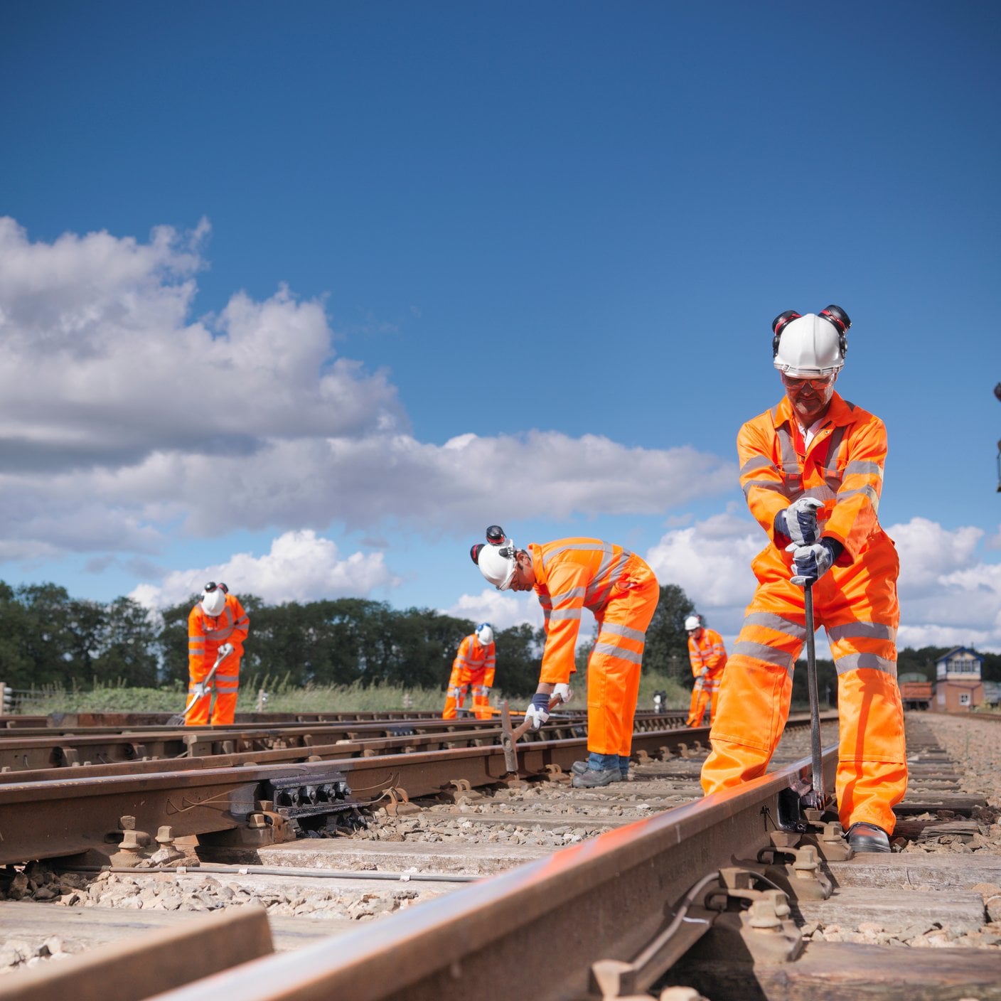 Railway workers wearing high visibility clothing repairing railway track