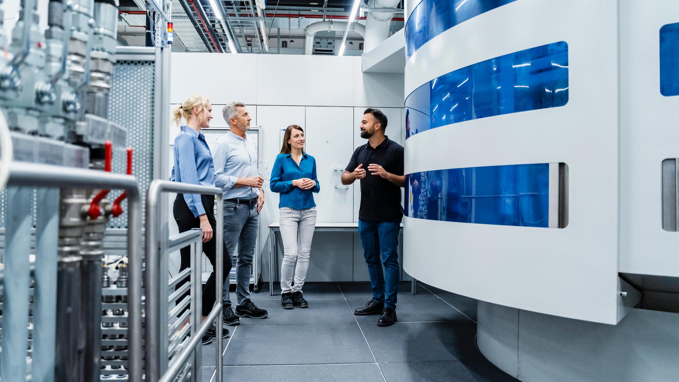 Ingenieur im Gespräch mit einem Geschäftsmann und einer Geschäftsfrau in der Industrieautomation