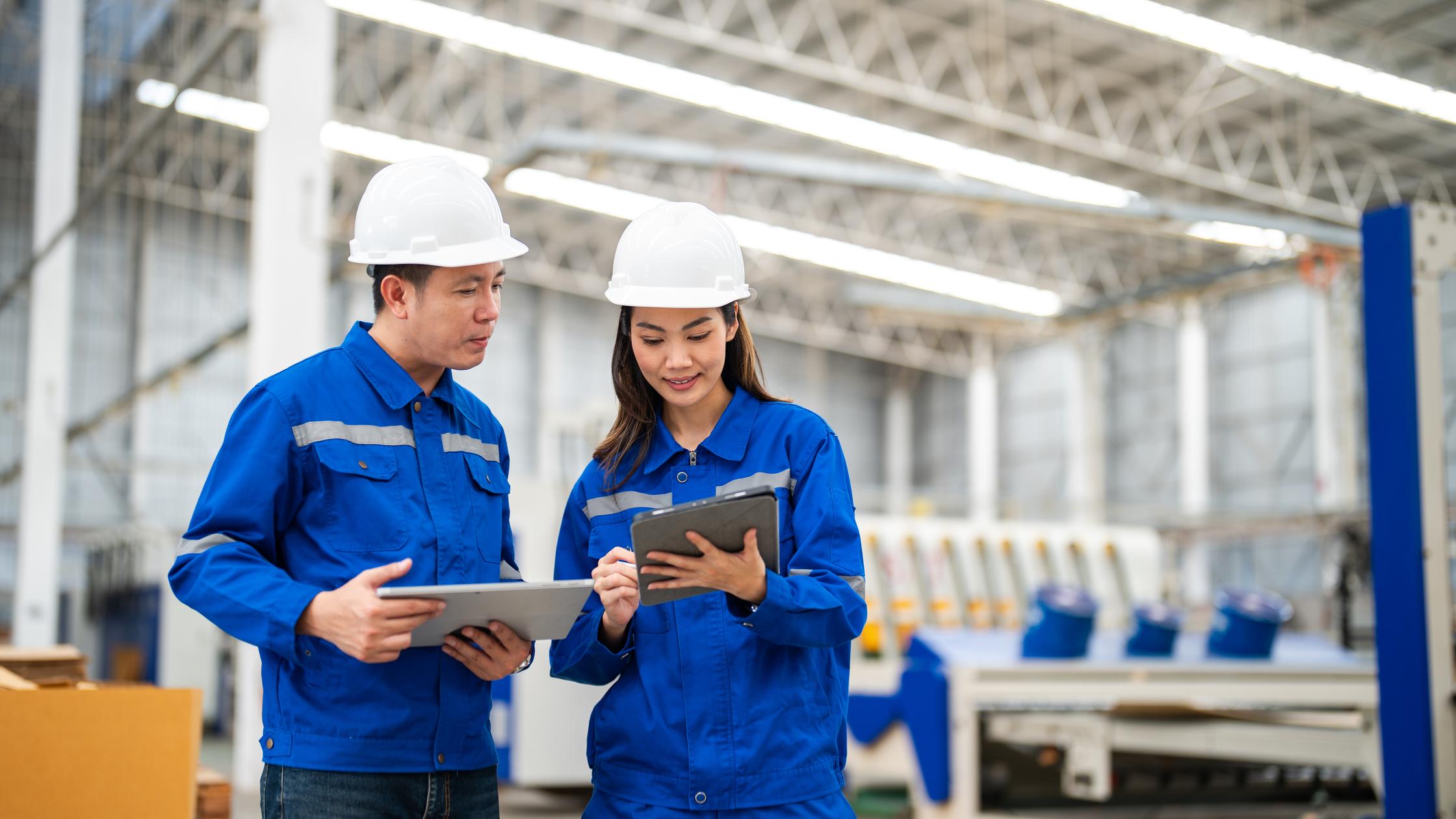 Two managers performing a manufacturing quality check in a warehouse