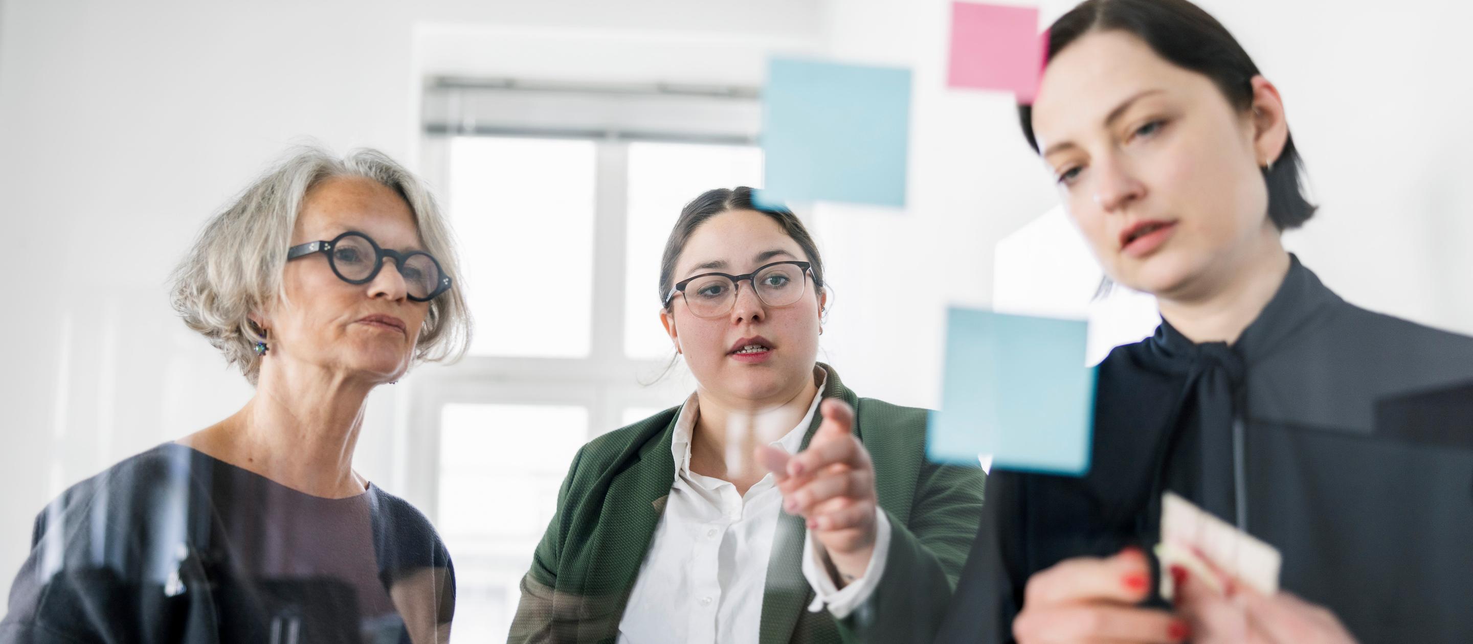 Female professionals planning strategy in a meeting at creative office.
